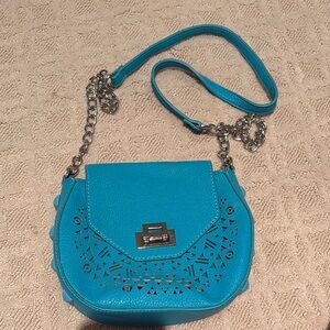 Intricate turquoise leather bag with cutouts and studs
